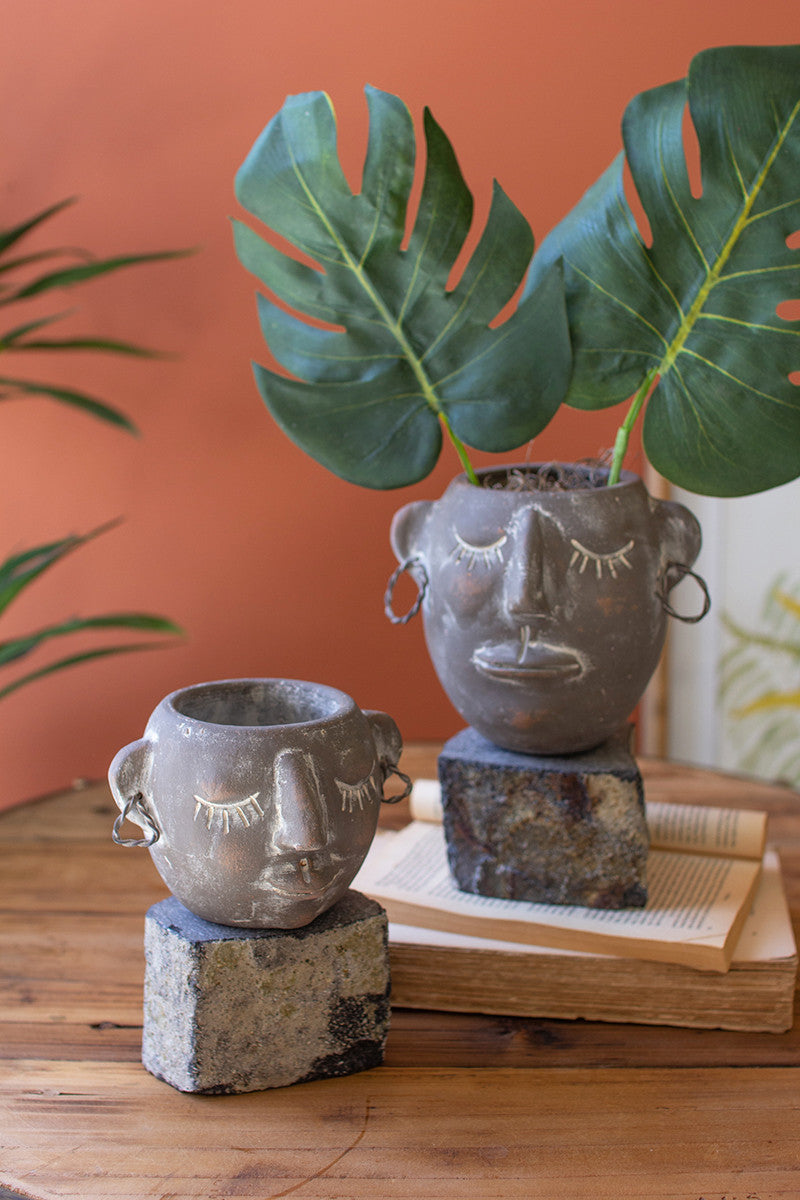 Two Clay Face Pots With Rock Base