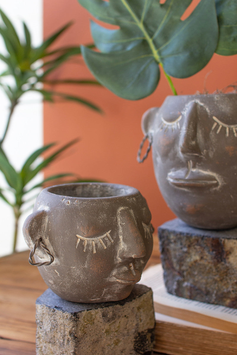 Two Clay Face Pots With Rock Base